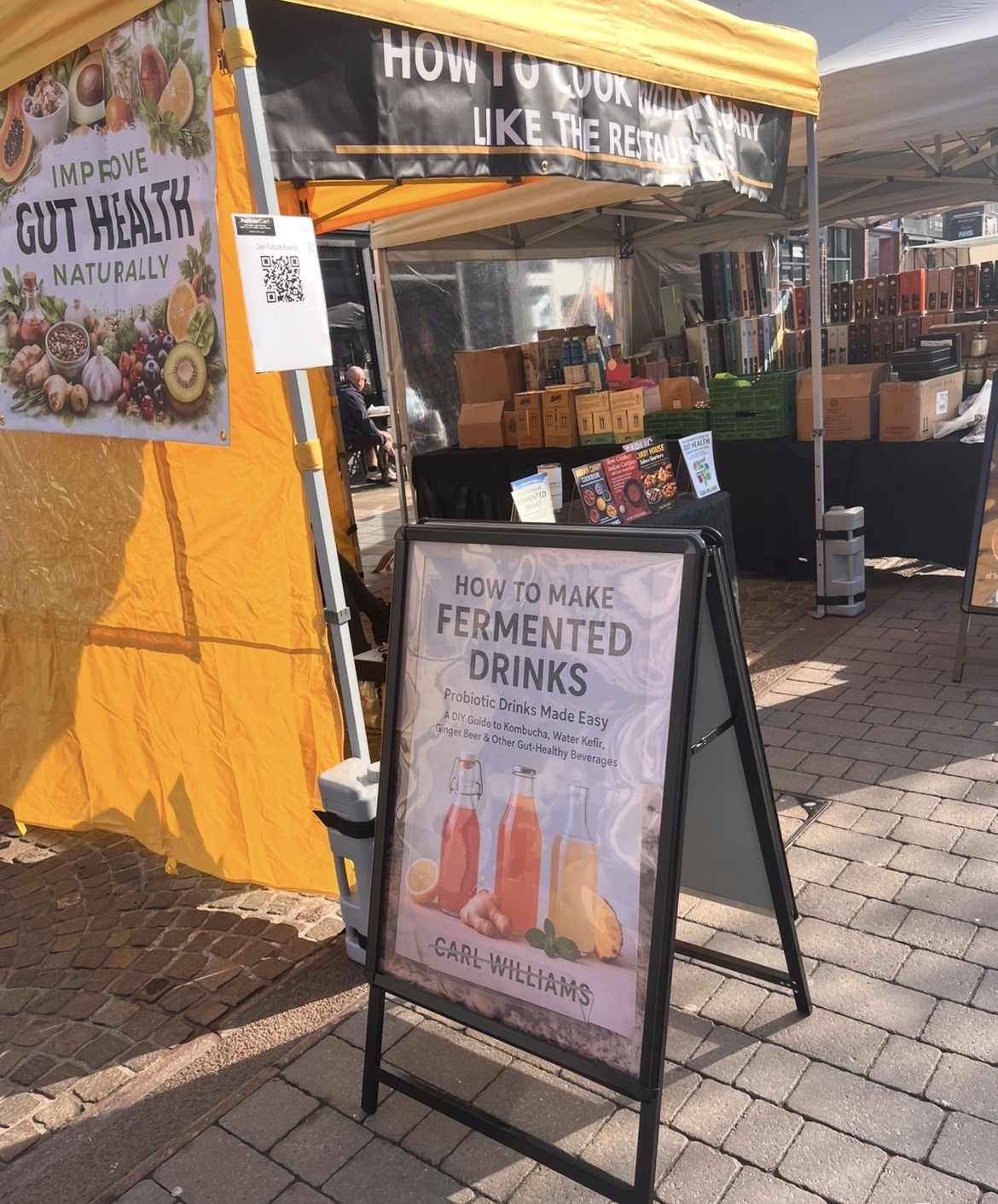 Author Carl stall at Ormskirk Market in West Lancashire with yellow gazebo and book display
